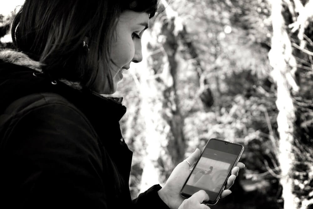 Black and white image of girl on phone for best online English teacher