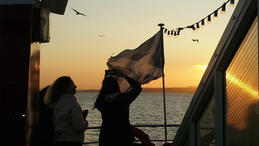 relax on your English language holiday - boat with Scottish flag and sunset