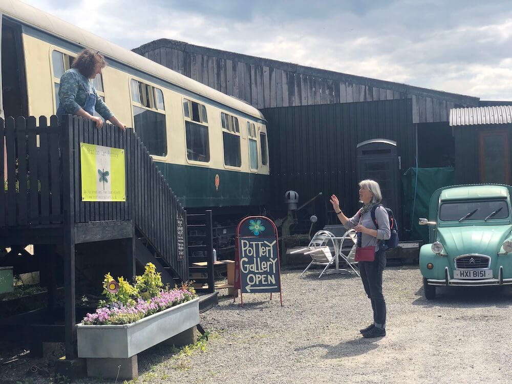 Senior language holiday visiting artist studio in railway train - real world english practice