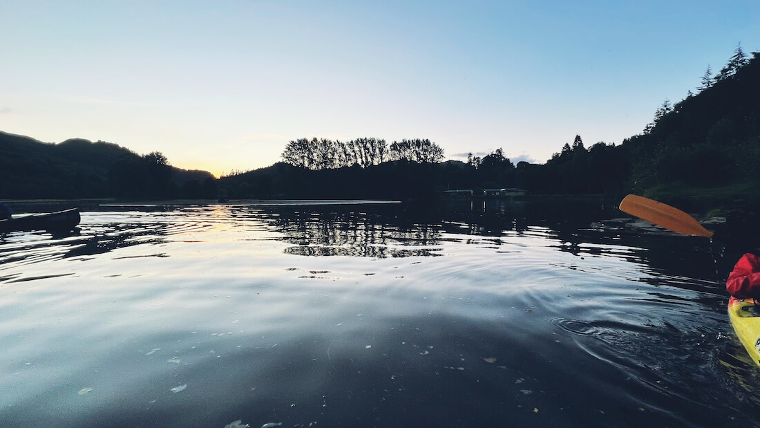 Canoeing on Loch Faskally at dusk during an autumn English holiday in Scotland.
