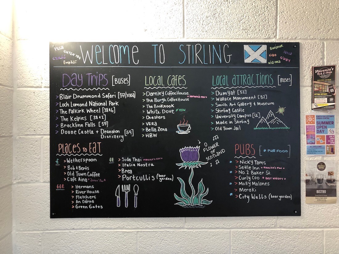 Blackboard at Stirling Youth Hostel listing things to do, places to eat, bus information and typical restaurant prices for visitors to Scotland.